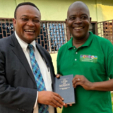 /media/orig/Le-president-de-linterregion-dAfrique-centrale,-Thierry-K.-Mutombo,-remet-un-exemplaire-du-Livre-de-Mormon-au-reverend-Nicholas-SINGA-GBASIA,-president-de-lAlliance-des-Eglises-evangeliques-de-l.png