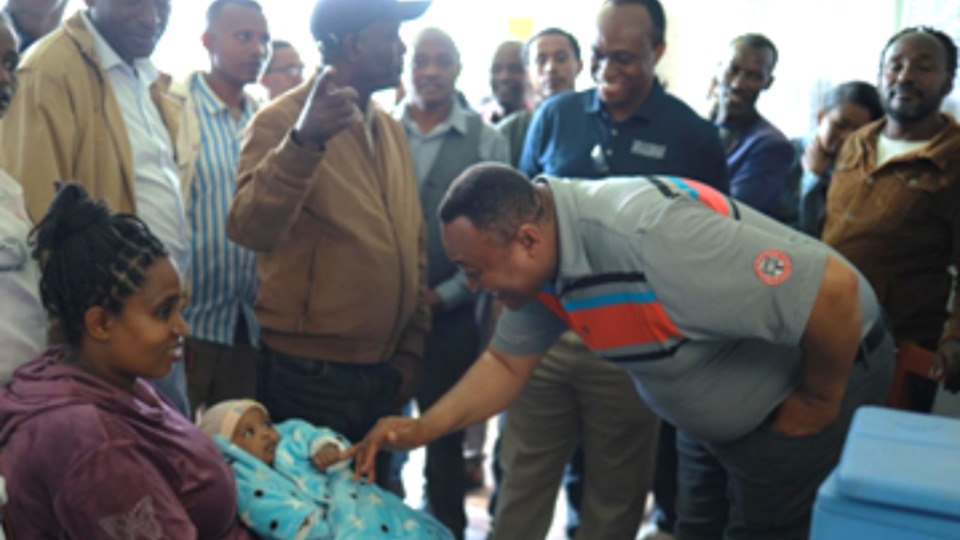 Elder Mutombo salue Bizunash Abera et son bébé lors de sa visite au poste de santé de Zemene Wulisho en Éthiopie, avril 2026.