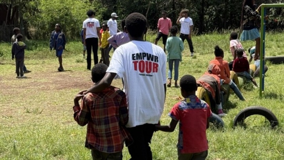  Un jeune adulte seul (JAS) accompagne des garçons sur le terrain de football pour participer à un match à l'orphelinat de Riuru. 15 novembre 2025
